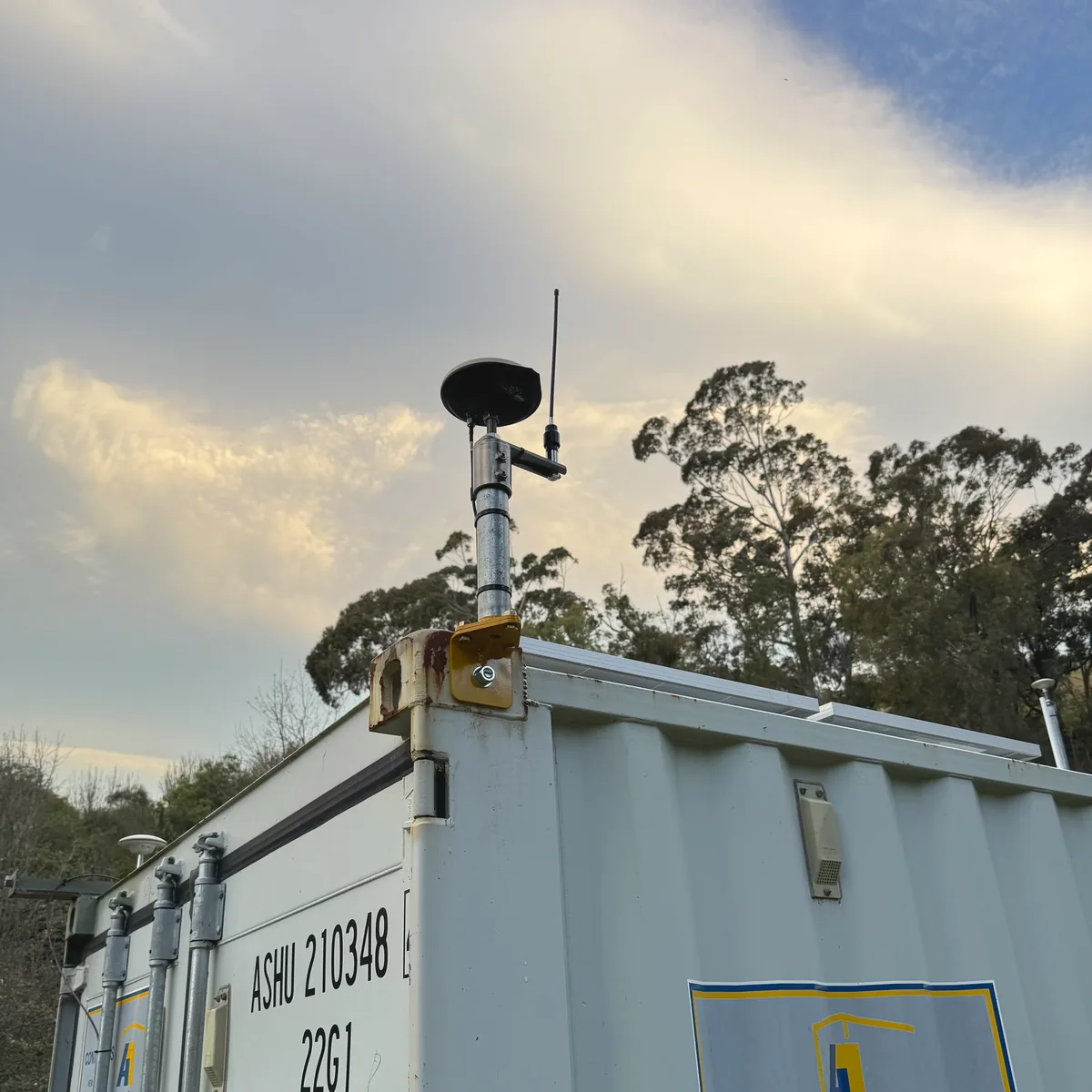 GNSS antenna and UHF radio whip mounted to the corner casting of a shipping container